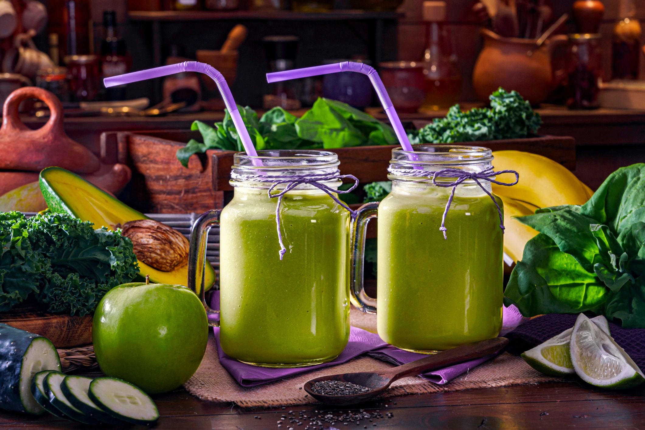 Green protein smoothies with fresh ingredients on a kitchen table