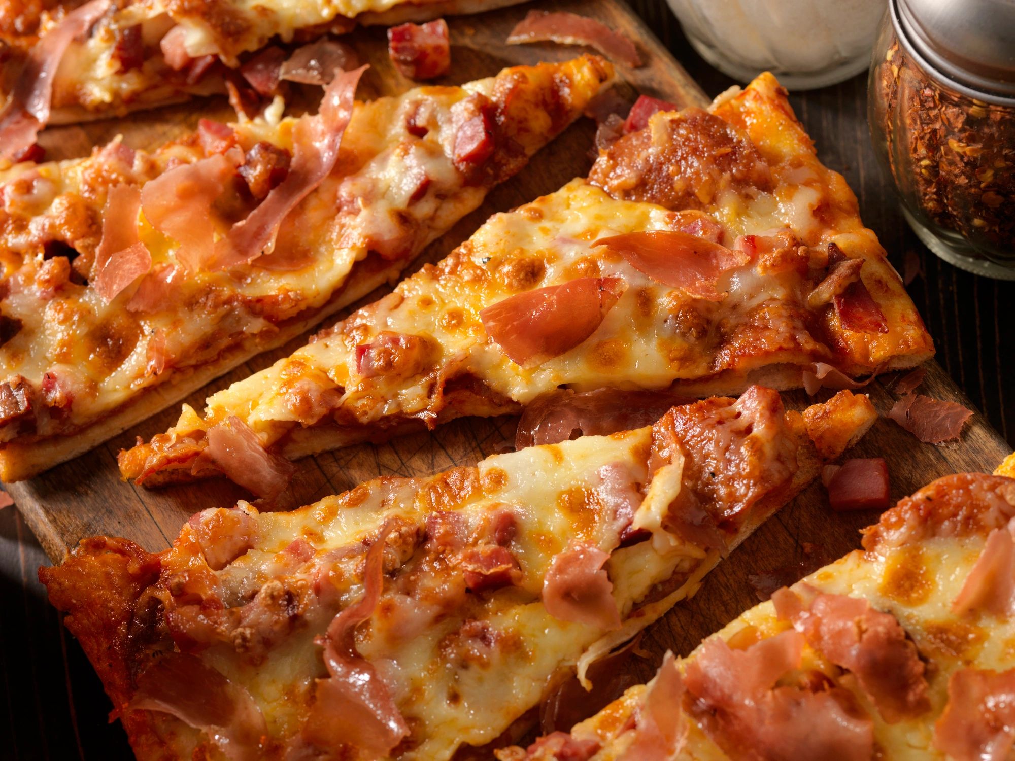 Flatbread pizza topped with meats and melted cheese