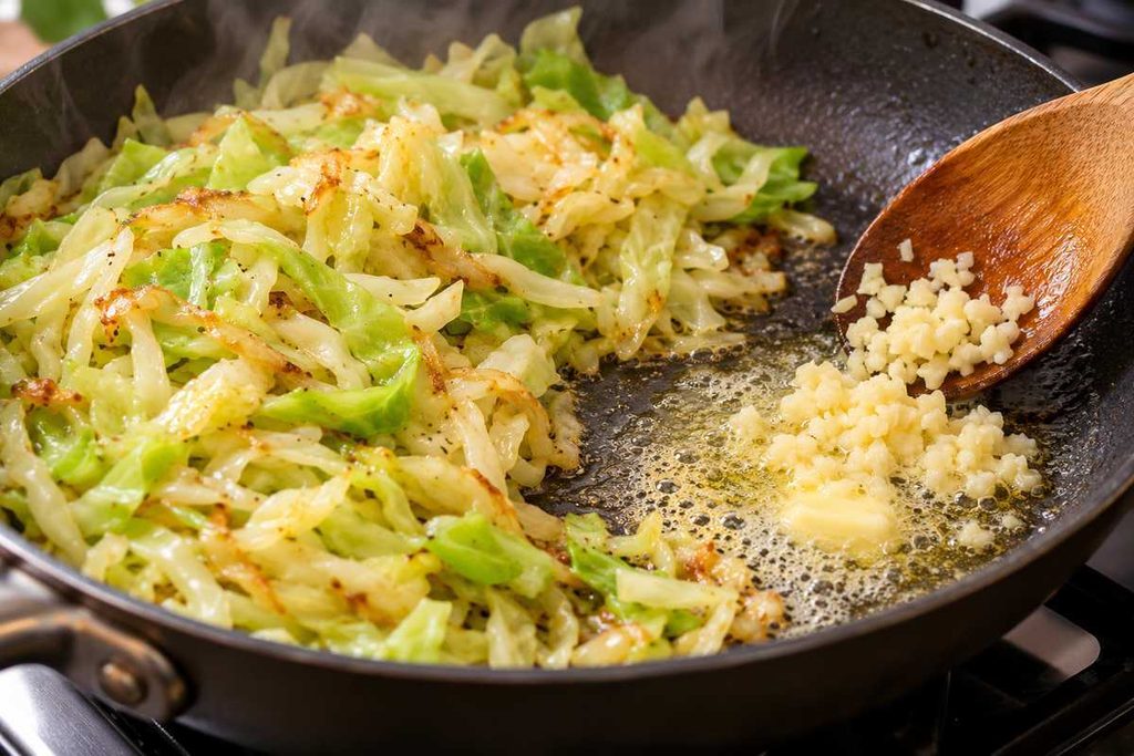 Cabbage Alfredo: Creamy Garlic Parmesan Cabbage Skillet 4 Minced garlic melting into butter beside sautéed cabbage in a skillet