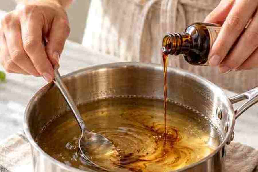 Caramel Syrup for Coffee: Easy Homemade Recipe 6 Vanilla extract being stirred into homemade caramel syrup after cooking