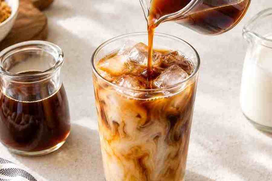 Caramel Syrup for Coffee: Easy Homemade Recipe 8 Homemade caramel syrup being poured into an iced caramel latte