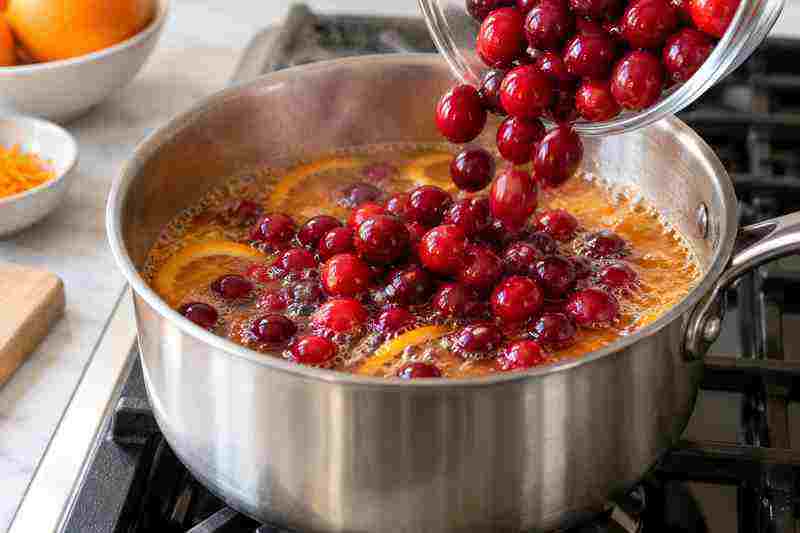 Homemade Cranberry Sauce Recipe With Orange 4 Fresh cranberries being added to the orange sugar mixture for homemade cranberry sauce