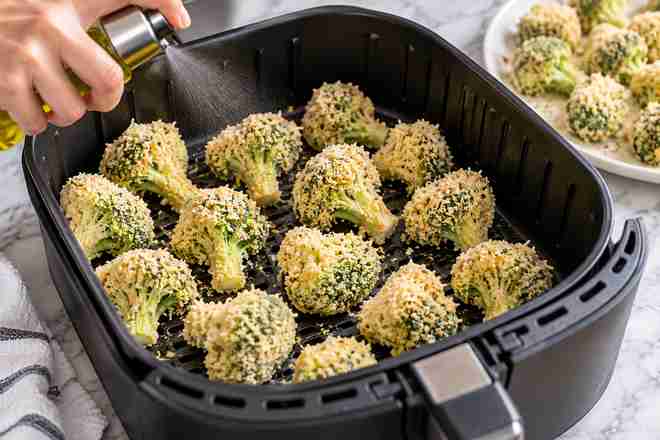 Breaded Broccoli Air Fryer Recipe (Golden & Crispy) 6 Uncooked breaded broccoli florets arranged in a single layer in air fryer basket